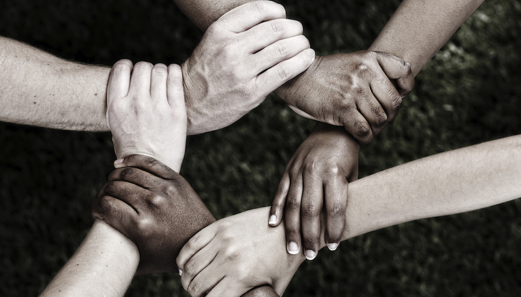 united we stand - six hands clasped together