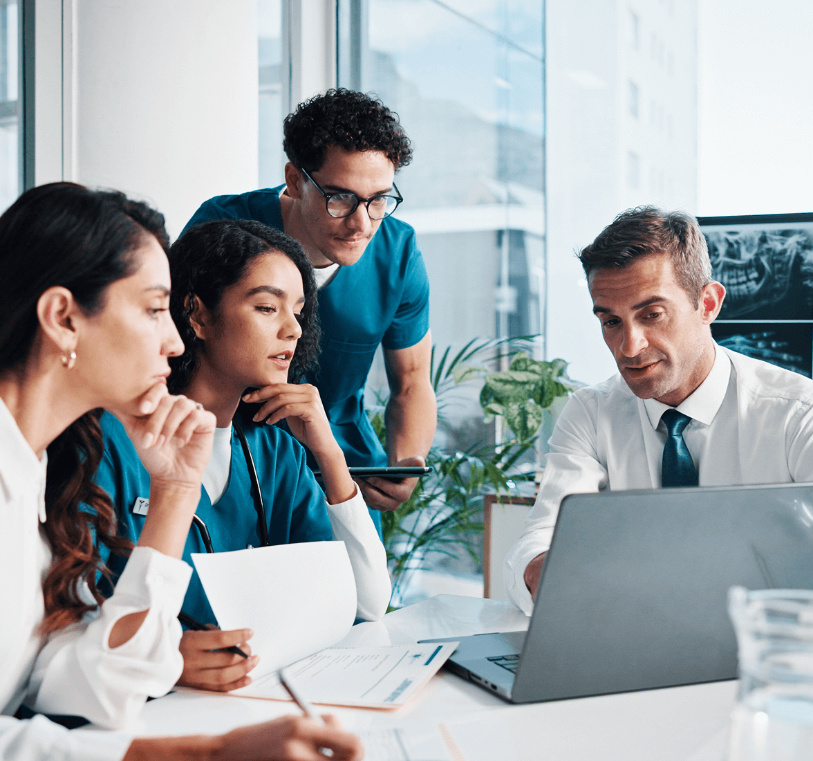 Four medical workers reviewing on a laptop