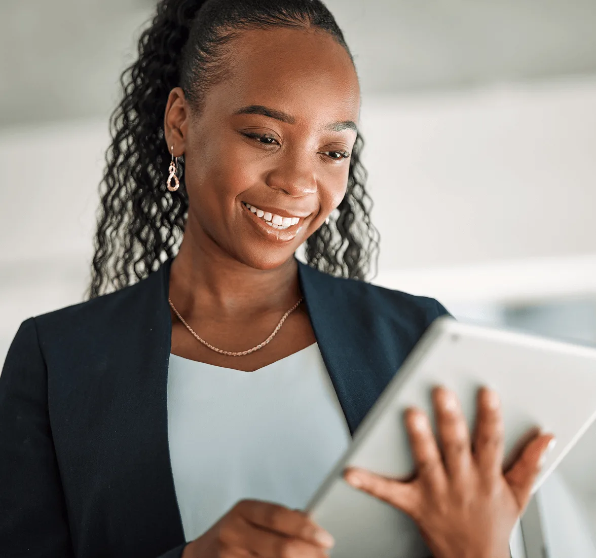 Person holding tablet looking at screen smiling